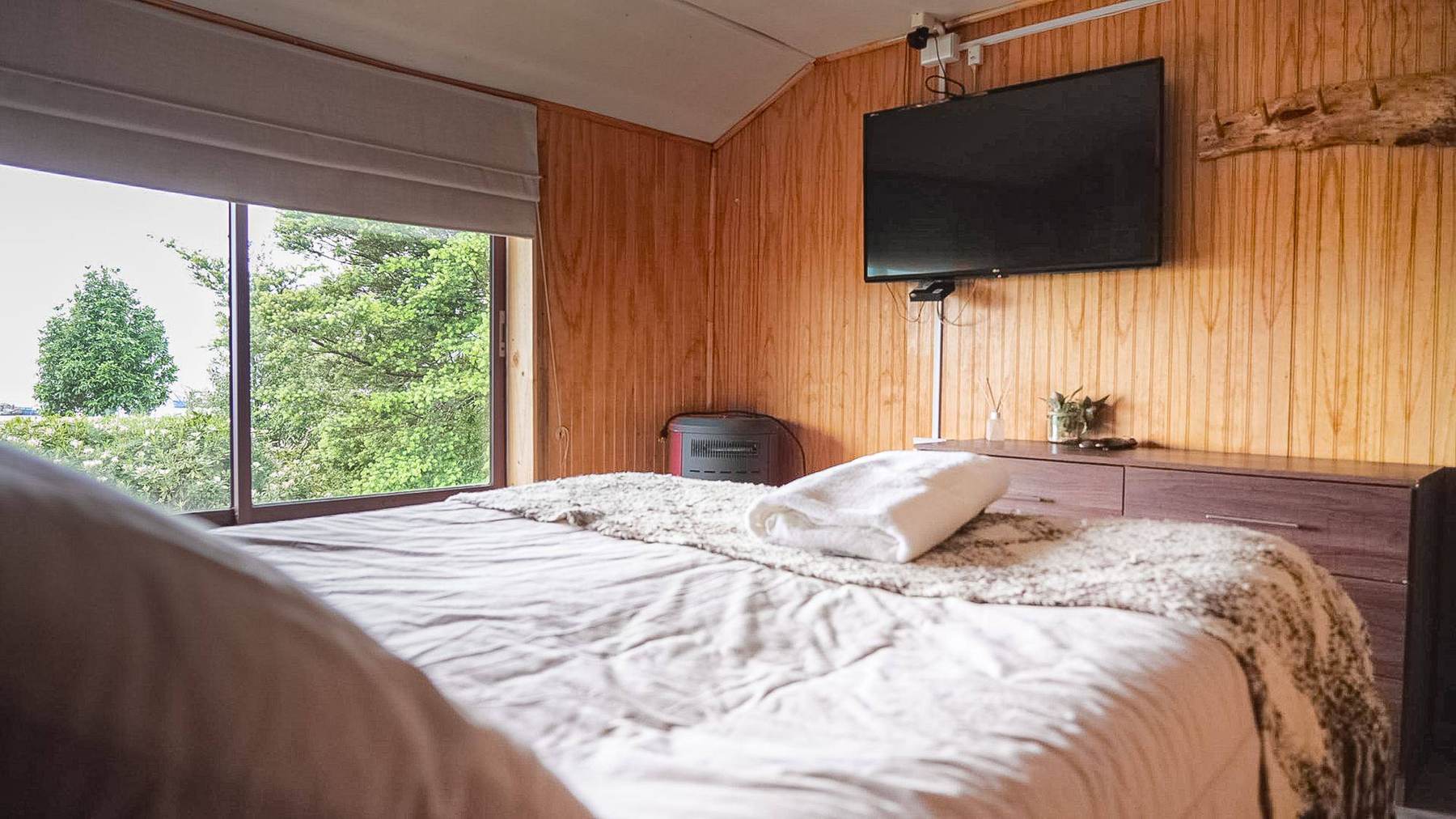 Gemütliches Zimmer mit Holzvertäfelung und Blick ins Grüne