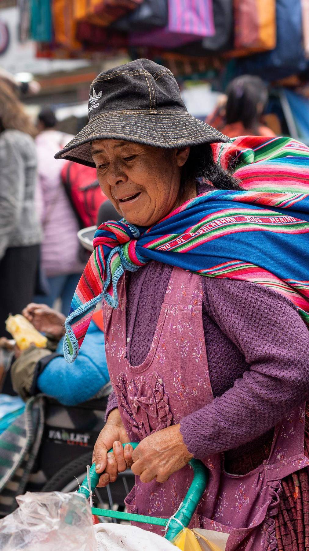 Frau mit gestreiftem Umhang auf einem Markt in Bolivien