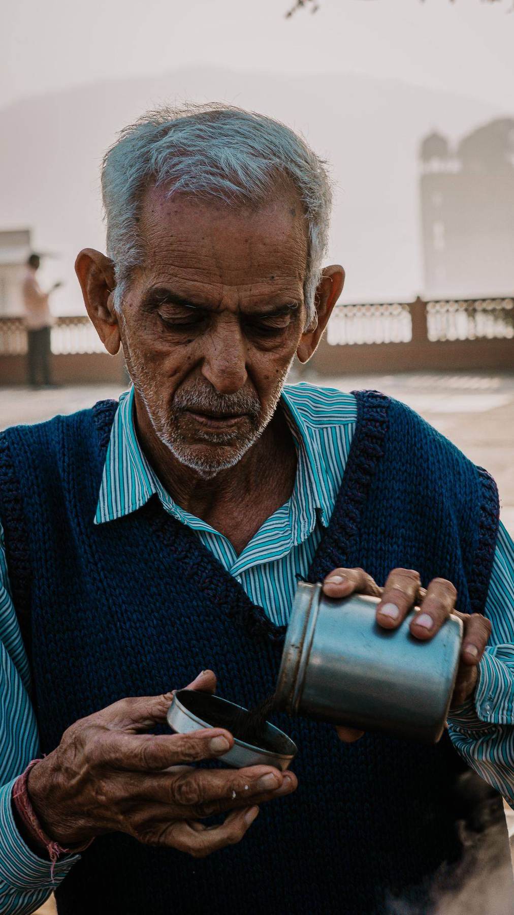 Älterer Mann gießt Chai in Indien