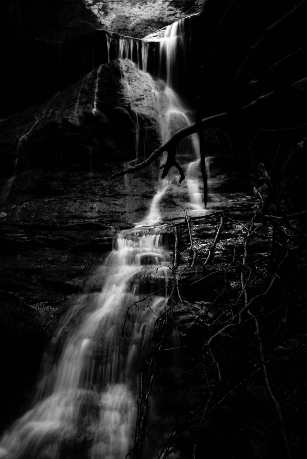 Wasserfall in Langzeitbelichtung über dunkles Gestein