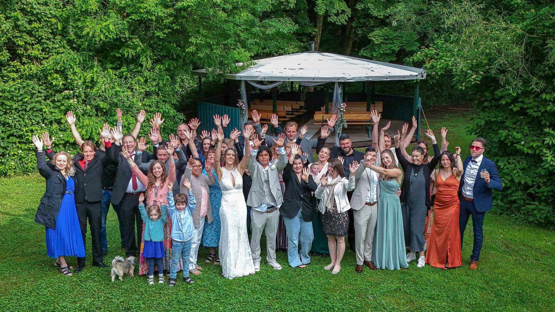 Hochzeitsgesellschaft jubelt gemeinsam vor dem Pavillon