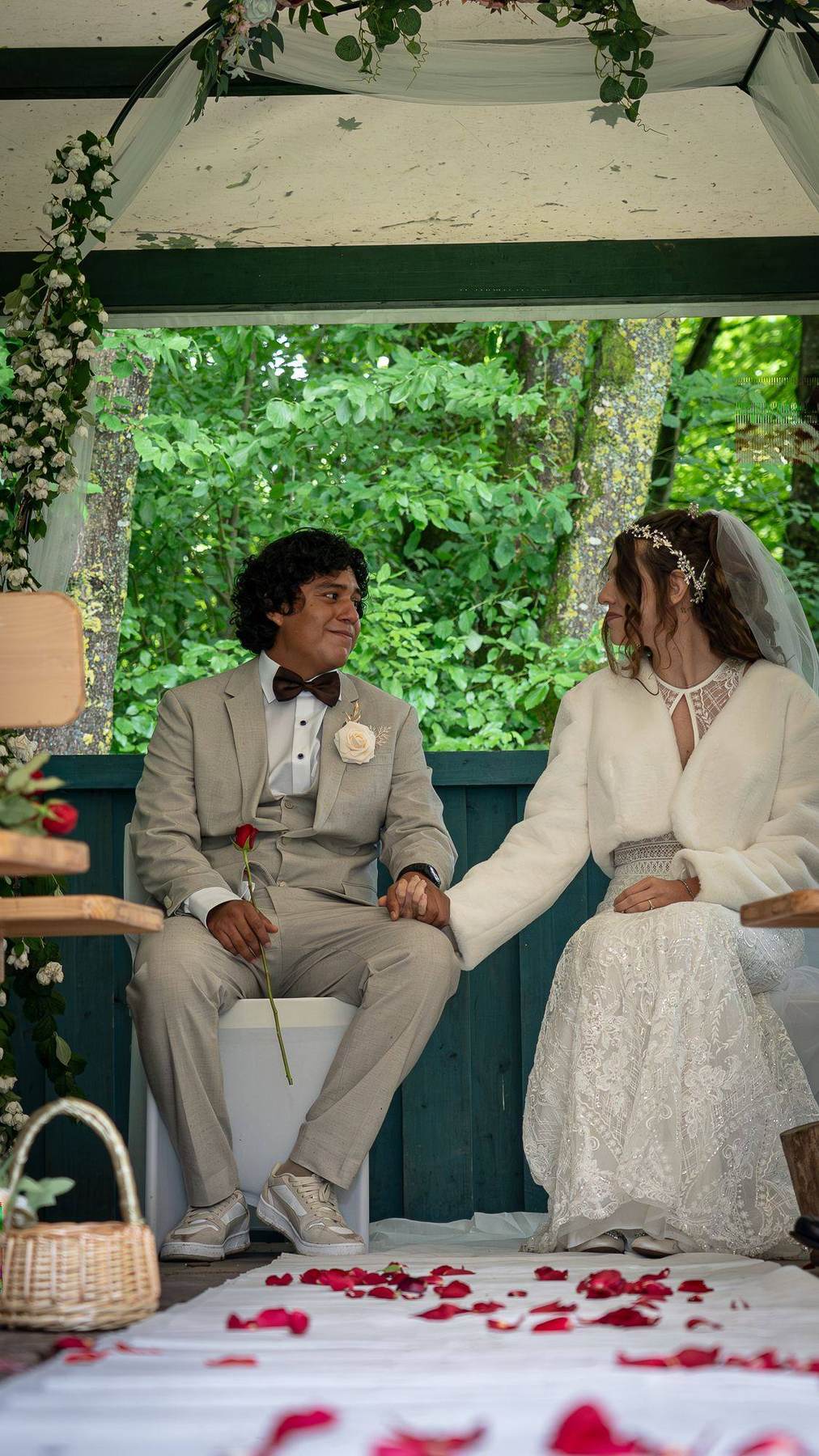 Laura und Brayan halten Händchen während der Zeremonie
