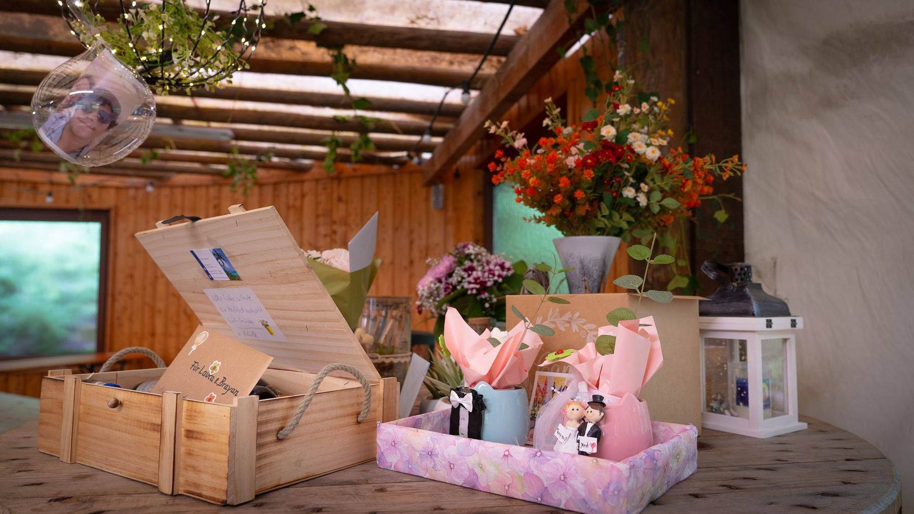 Geschenktisch mit Blumen und kleinen Brautpaar-Figuren