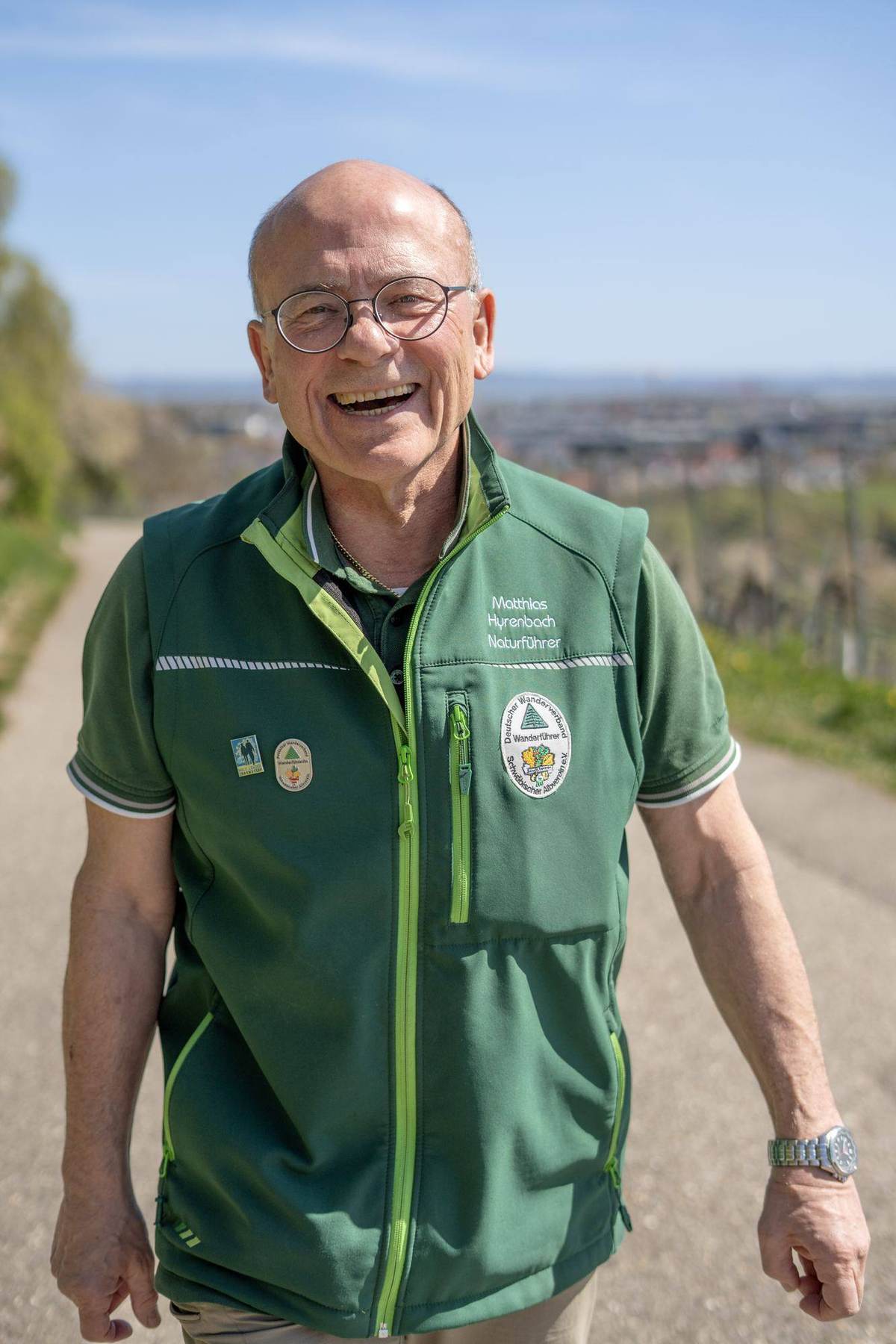 Matthias lacht auf dem Weg, im Hintergrund das Tal