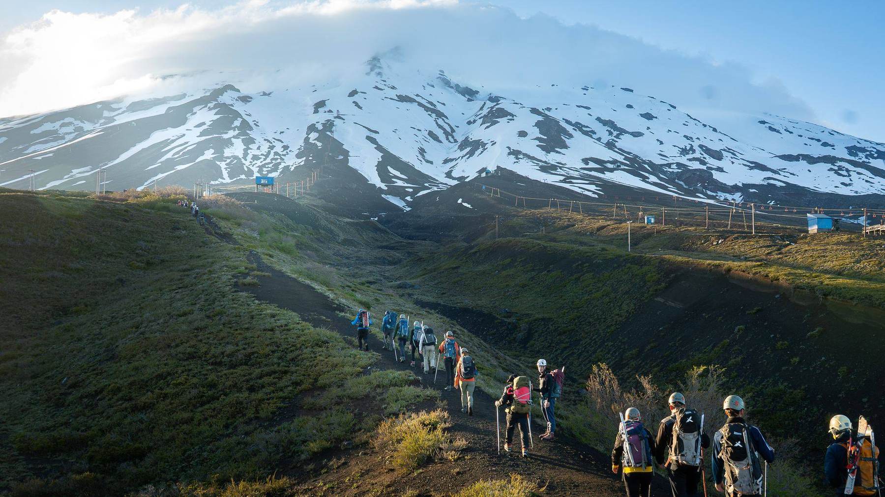 Die Gruppe auf dem Zustiegsweg mit Blick auf den schneebedeckten Vulkan