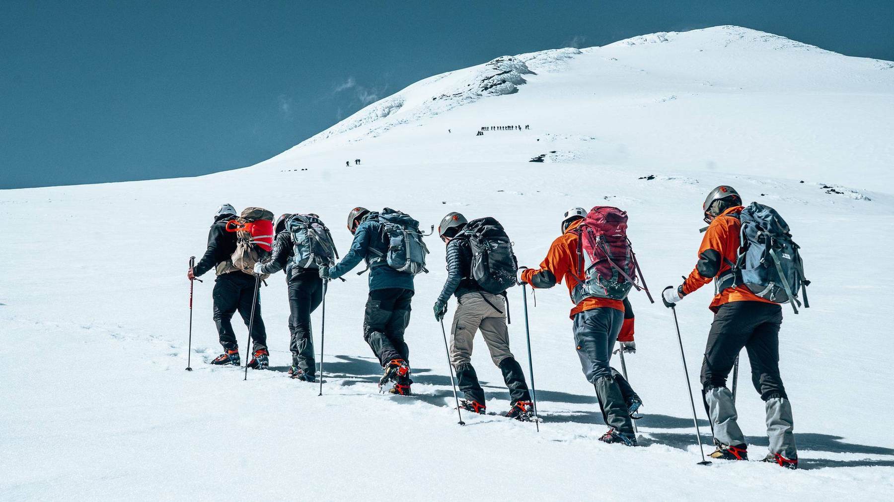 Aufstieg im Gänsemarsch über ein steiles Schneefeld, weitere Bergsteiger schon nahe dem Gipfelgrat