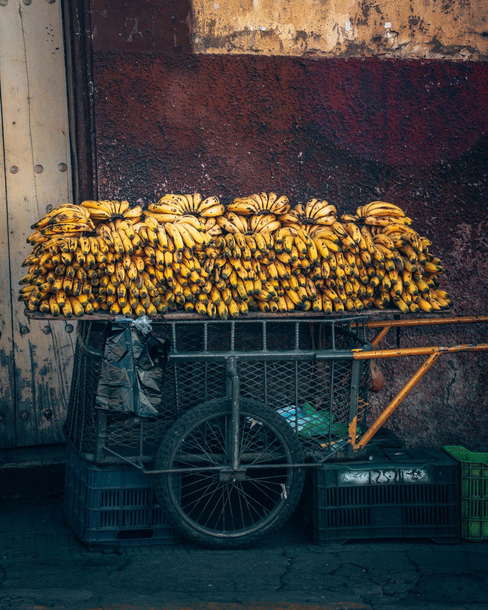 Bananenkarren vor einer verwitterten Wand auf einem Markt