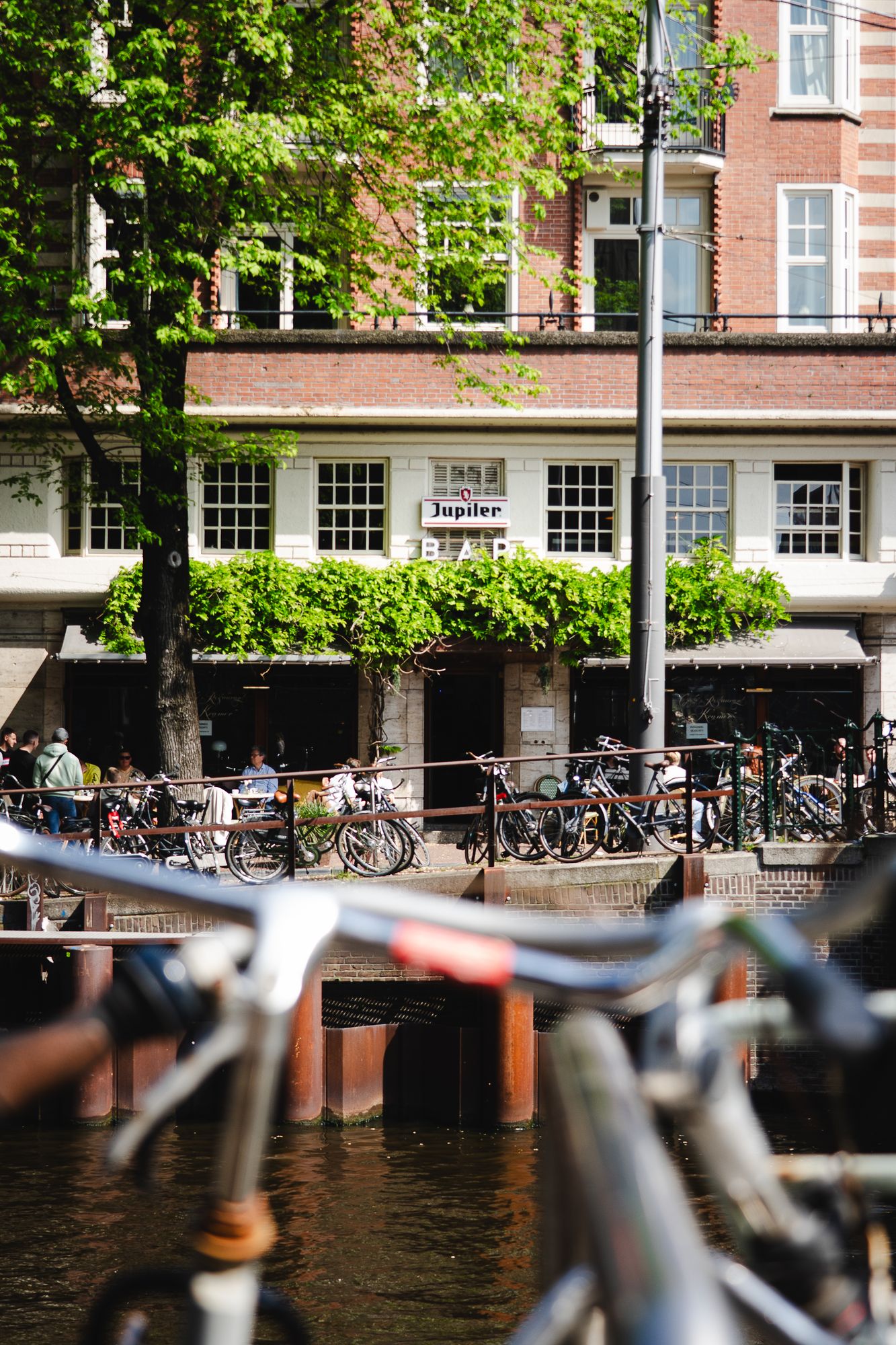 Gracht in Amsterdam mit Fahrrädern und Café am Ufer